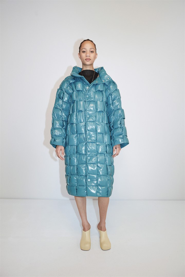 同じ膨らみを服に応用した、水色の光沢のあるロングコート